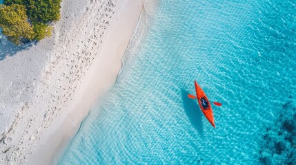 Obraz premium A serene aerial view of a kayak gliding through crystal-clear turquoise water near a sandy beach, capturing the essence of tranquility.