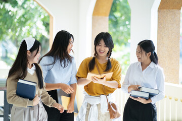 Group of students walking in campus hallway .