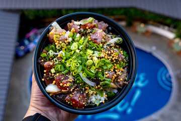 Poke Bowl with a Hotel Swimming Pool in the Background