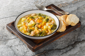 Autumn vegetarian Frantoiana soup with beans, potatoes, pumpkin, kale, carrots, onions and celery close-up in a bowl on the table. Horizontal