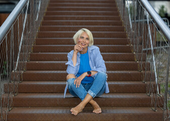 Portrait of attractive woman sitting on a staircase of an office building