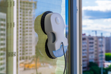 Robot window cleaner washes glass with round rags, robotic service, modern technologies