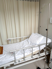 Adjustable Hospital Bed With Pillow And Blanket And Intravenous Stand In A Hospital