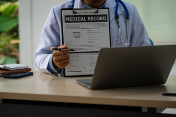 A male doctor sits at a desk in the heart clinic, consulting online and giving advice. The vascular...