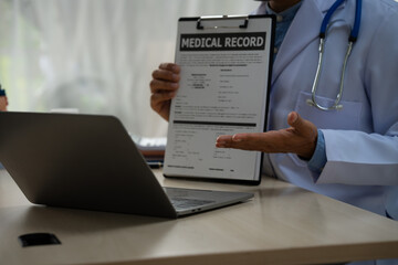 A male doctor sits at a desk in the heart clinic, consulting online and giving advice. The vascular surgery clinic offers an electrocardiogram service with modern technology and expert care.