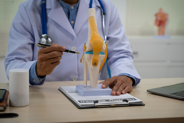 A male doctor in leather works at the table in the bone disease clinic, addressing issues such as...