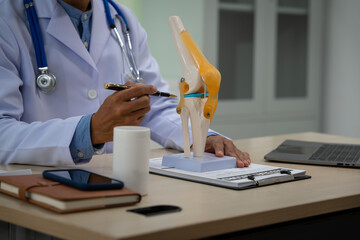 A male doctor in leather works at the table in the bone disease clinic, addressing issues such as...