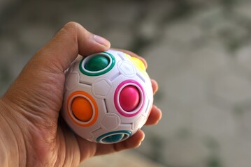 A hand holding colorful toy ball