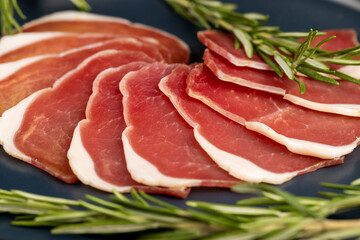 sliced ham with bacon on a board