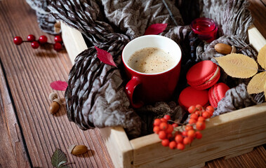 Autumn, fall leaves, hot steaming cup of coffee and a warm scarf on wooden table background. Seasonal, morning coffee, Sunday relaxing and still life concept.