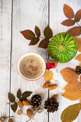 Autumn, fall leaves, hot steaming cup of coffee and a warm scarf on wooden table background. Seasonal, morning coffee, Sunday relaxing and still life concept.