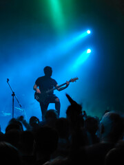Musician guitarist playing guitar solo in blue spotlights on stage