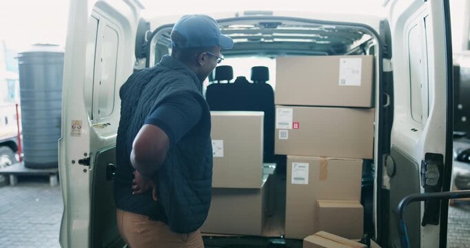 Black man, delivery and back pain with box from accident, lifting or heavy cargo in van or vehicle. Young African or courier guy with sore spine, muscle or joint injury in logistics or transport