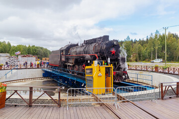 The retro locomotive turns around on a special platform. Ruskeala, Karelia, Russia - September 2, 2022.