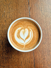 Top view fresh coffee with milk foam and latte art on  wooden background