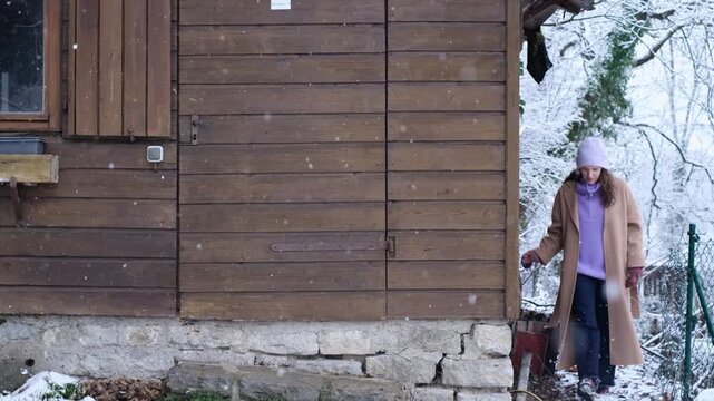 Curious caucasian woman explore an abandoned wooden cottage, carefully looking around if anybody see her. Nosy neighbour stalking or snooping secrets, gossip and rumour. Stalker peeping people.