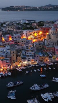 vertical aerial video of Procida island in Italy at night, Procida is an island near Naples with traditional fishing village in the bay of Naples