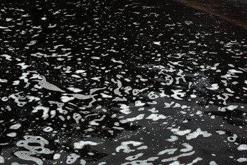 Black waste water with white foam on water surface environmental pollution of nature from effluent factory.