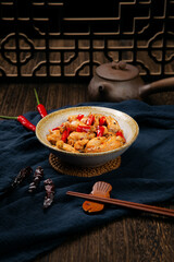 Spicy bullfrog in bowl on wooden tabletop and dark background