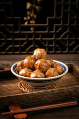 Beef meatballs on wooden table, interior scene with dark background