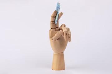 Wooden hand holding 20 euro banknote isolated on white background. Copy Space. Concept of money, finance, economy, euros