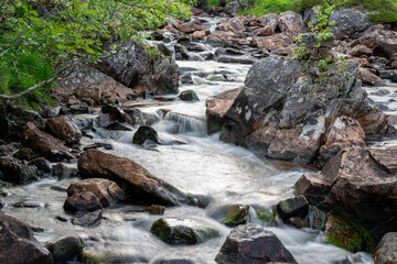 waterfall in the woods of Andalsnes Norway in summer evening fjord