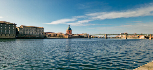 La Grave Hospital Reflecting in the Garonne River at Sunrise with Saint Pierre Bridge, Bathed in Golden Sunrise Light Under a Clear Blue Sky, Toulouse