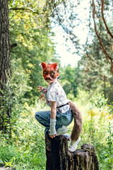 A girl with cat mask, tail and gloves doing Quadrobics in the forest.