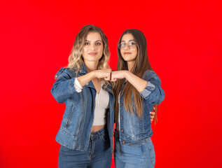 Fist bump, young caucasian friends two women confident 20s wearing denim jacket and jeans looking...