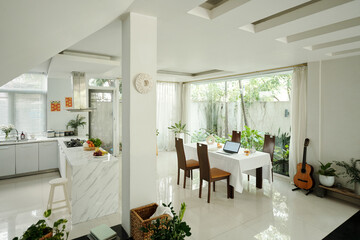 Dining table in white design kitchen in modern apartment
