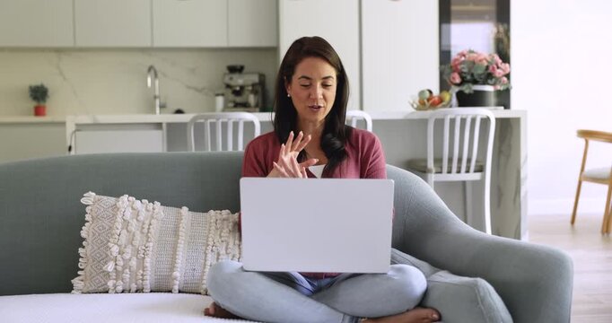 Attractive female psychologist working from home, making call, provide professional support to client remotely using laptop, platform or apps. Freelance job, modern tech usage, virtual meeting event