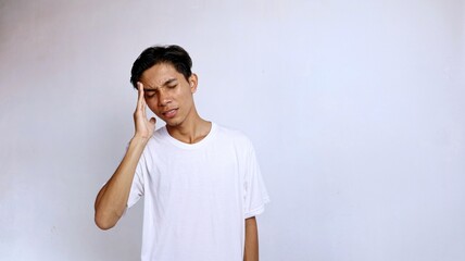 Asian young man wearing white shirt gesture hand holding head . headache