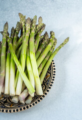 Asparagus sprouts on plate. Vegetable vegan food top view.