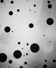 monochromatic features pattern black dots and circles on white background, creating sense depth and movement.