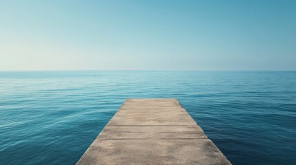 Fototapeta premium Concrete Pier Extending Into Tranquil Blue Sea