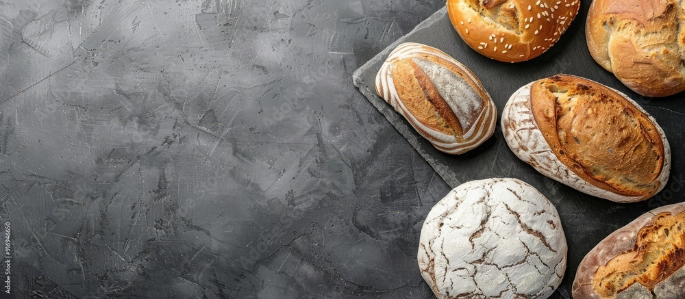 Poster various types of bread displayed on a stone surface from above, with room for additional content in 