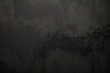 Fototapeta premium Fondo de textura rugosa de pared negra, suelo de hormigón o fondo antiguo grunge, iluminado por rayos de sol. Primer plano de la superficie de grafito oscuro para un diseño de fondo moderno.