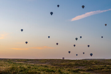 Hot air balloons floating above the hot rising sun