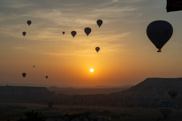 A photo of a hot air balloon taken backlit at sunrise time.