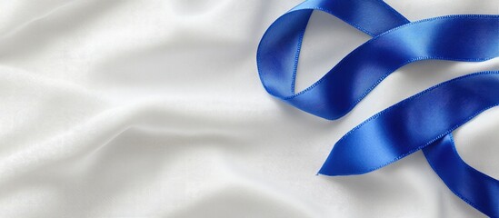 A deep blue ribbon curl on white fabric with copy space Colorectal cancer awareness colon cancer in older adults and World Diabetes Day as well as child abuse prevention Healthcare and insurance them