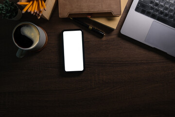 Modern workplace with smart phone notebook on wooden table. Copy space and blank screen for your advertise design.