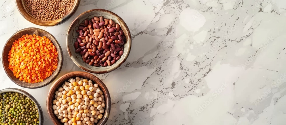 Aufkleber assorted legumes lentils chickpeas and beans in various bowls on a white table top view with copyspa
