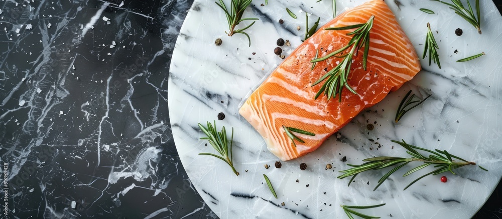 Poster top view of a rosemary seasoned salmon fillet on a marble plate perfect for making a delicious salmo