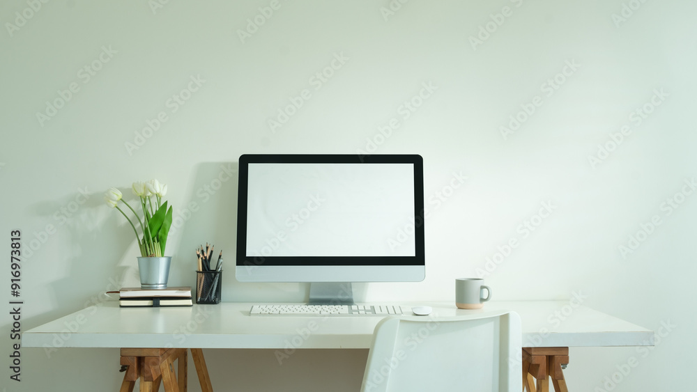 Poster front view of blank computer monitor on white table in home office, for graphic display montage.