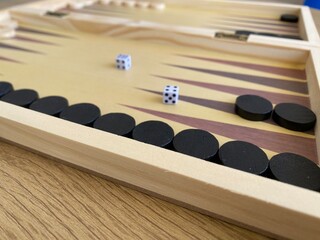 Naklejka premium Backgammon game. Wooden board with backgammon game pieces with dice