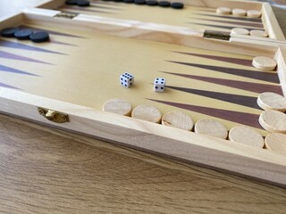 Naklejka premium Backgammon game. Wooden board with backgammon game pieces with dice