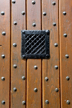 Porte en bois clout&eacute; avec une grille pour voir le visiteur
