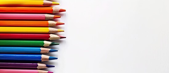 Fototapeta premium Colorful pencils stacked isolated on white with copy space image on the left side for creative artwork or school and office needs in a flat lay top view composition
