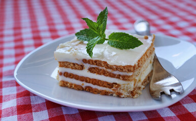 Cookie and cream dessert on a white plate decorated with mint