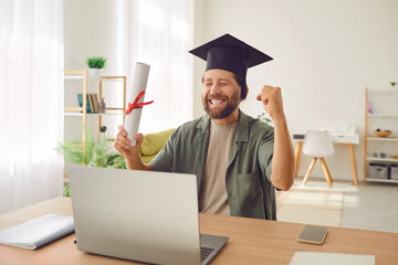 Online education, portrait of happy student in a mortarboard holding diploma, sitting with a...